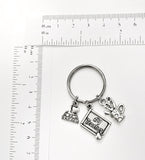 Teacher themed keychain. Includes #1 Teacher, Books with I Love to Read, and Art Supply Mug charms. Educator gift.