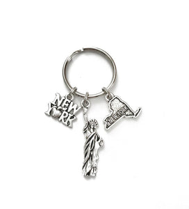New York themed keychain. Includes Includes New York State, New York Sign with Apple, and Statue of Liberty.